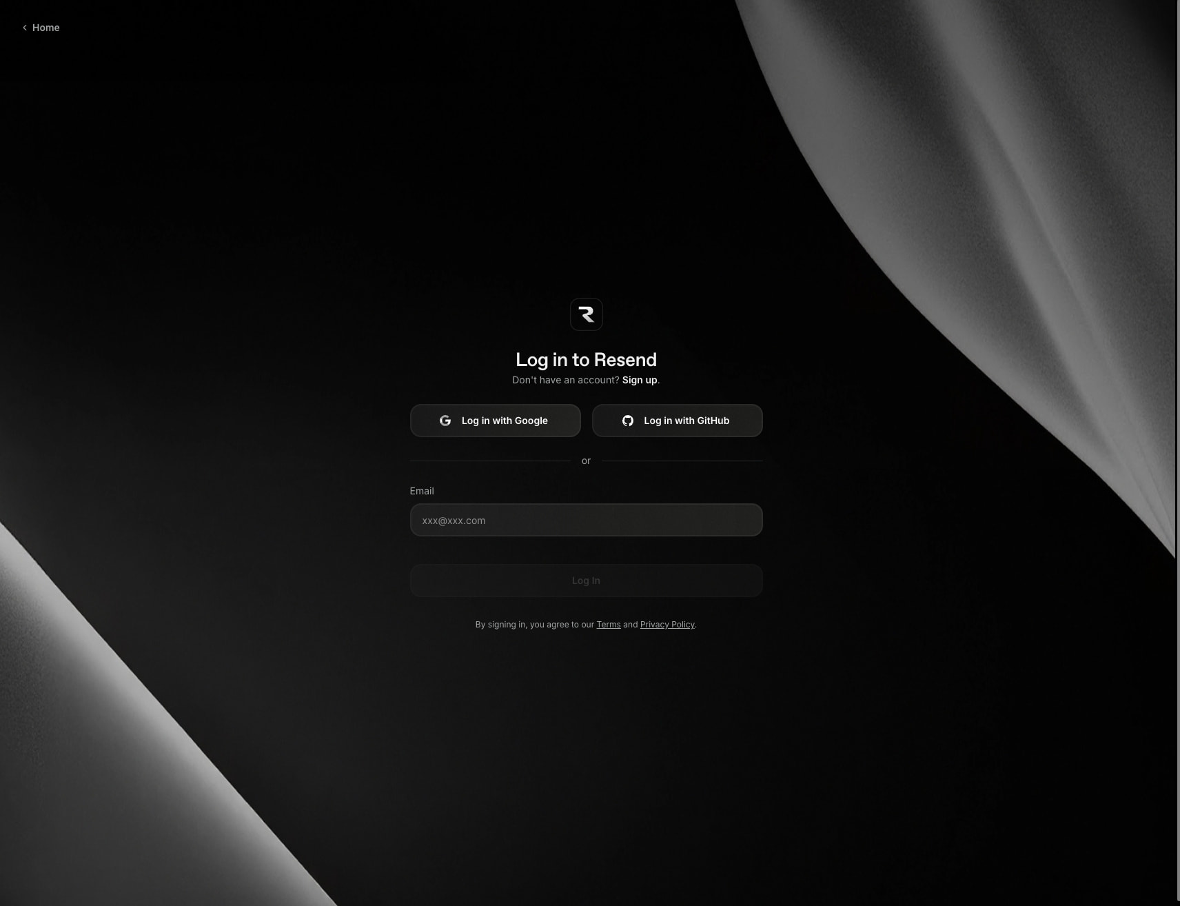 Login page with centered auth form, dark canvas, and abstract grayscale fabric photography framing the composition captured website design